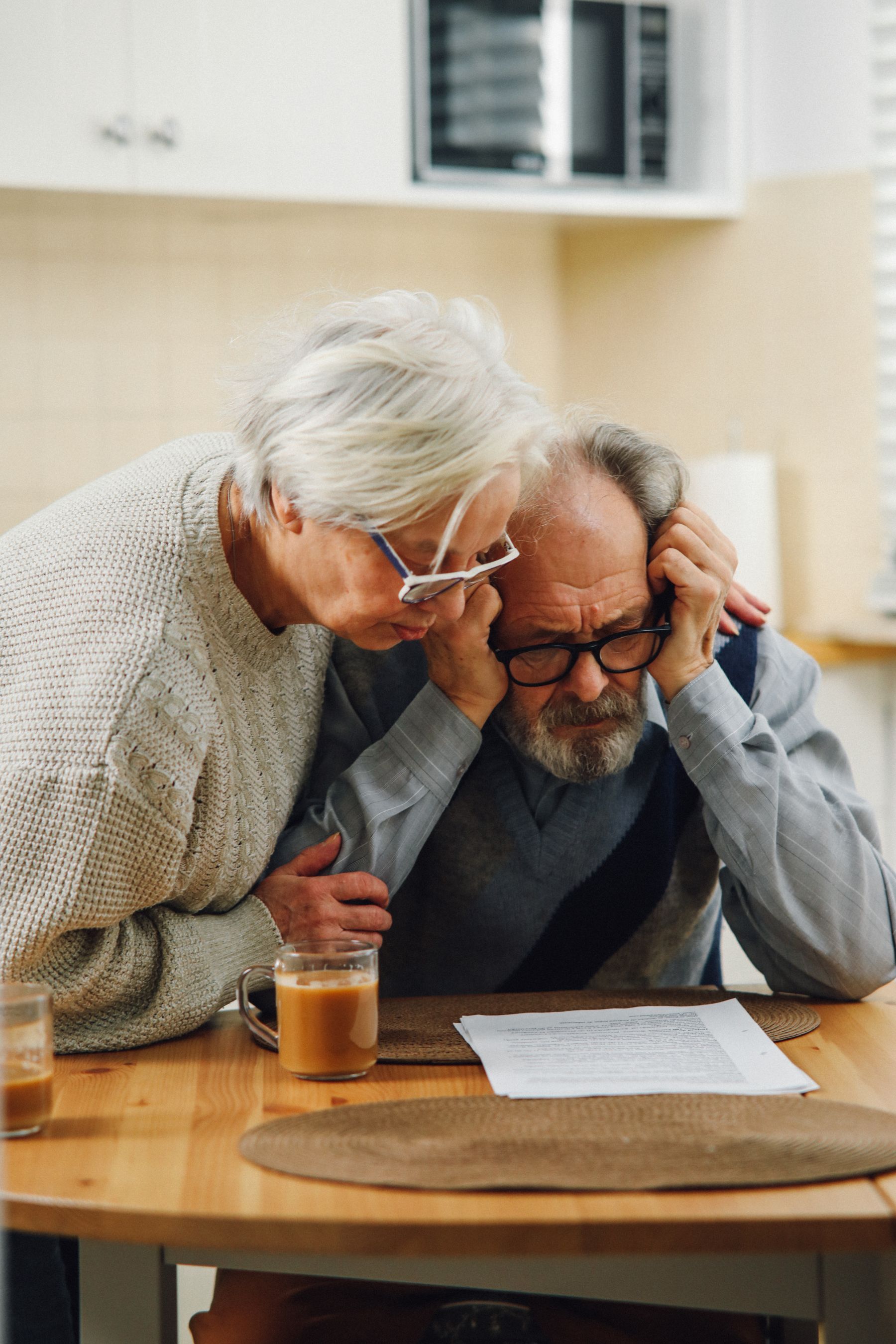 An older couple studying documents together at a kitchen table