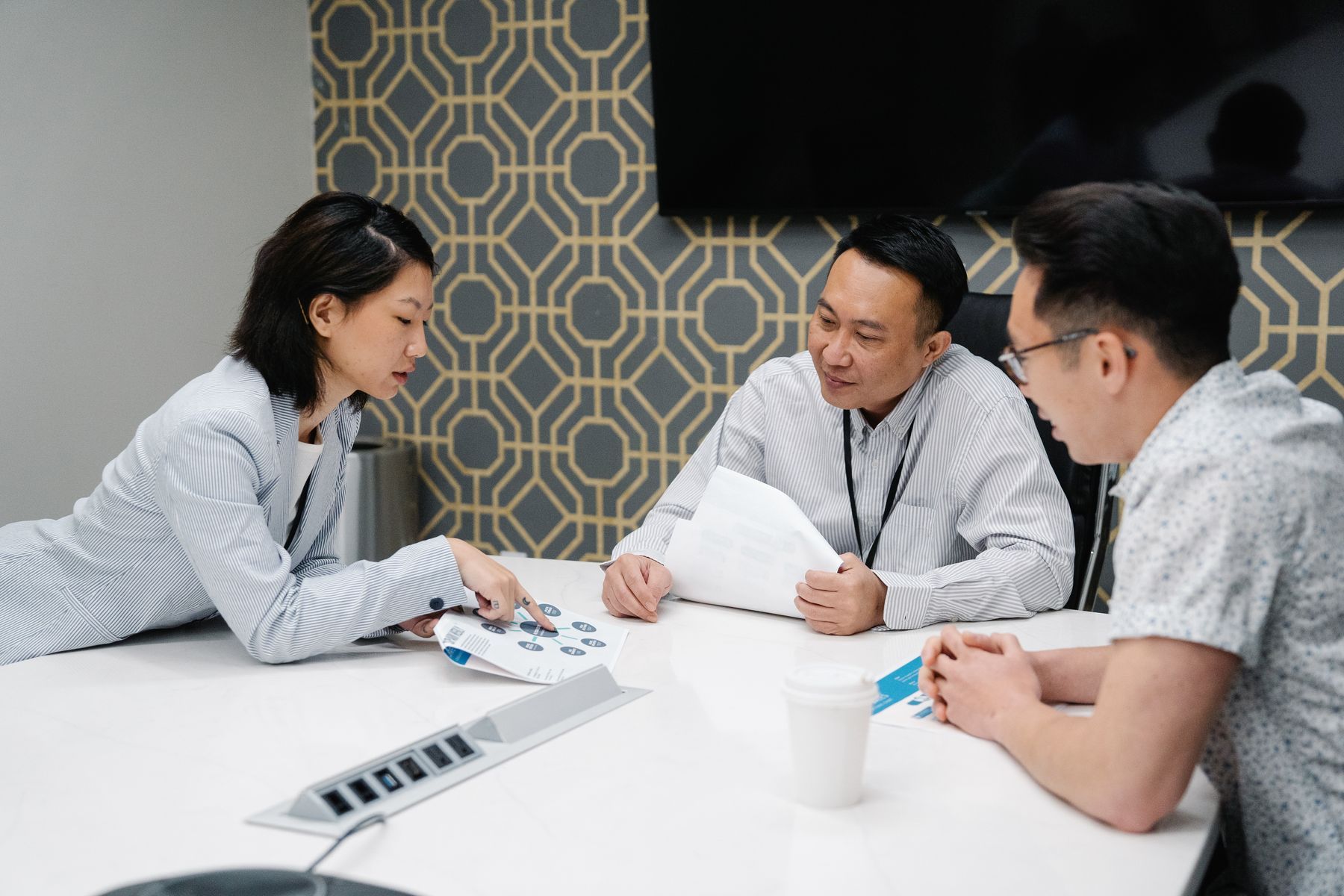 Three colleagues discussing case documents around a desk